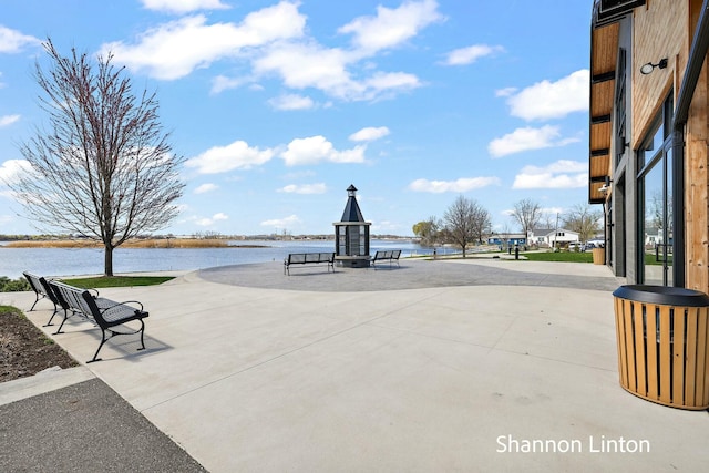 surrounding community with a water view and a patio area
