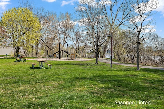 view of property's community featuring playground community and a lawn