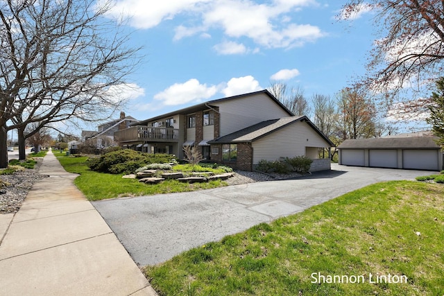 view of front of property featuring an outbuilding, a front lawn, and a detached garage