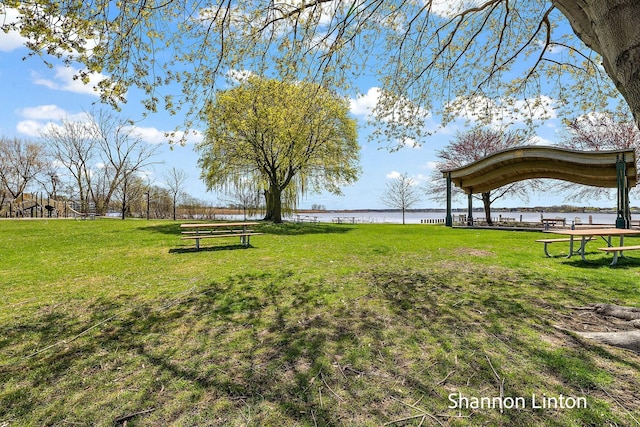 view of community featuring a water view and a lawn