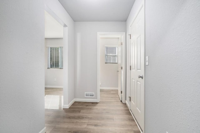 2710 Sanderling Ct, Grand Rapids, MI 49505 - hall with visible vents, wood finished floors, a textured wall, and baseboards