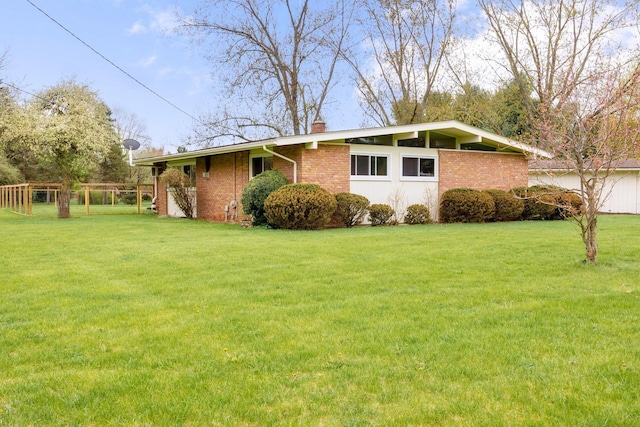 5009 John Holmes Rd, Ann Arbor, MI 48103 - view of side of property with a chimney, a yard, and brick siding