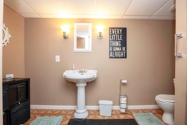 5009 John Holmes Rd, Ann Arbor, MI 48103 - bathroom with toilet, a drop ceiling, and baseboards