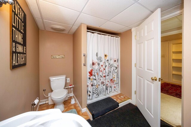 5009 John Holmes Rd, Ann Arbor, MI 48103 - full bathroom with toilet, curtained shower, baseboards, and a drop ceiling