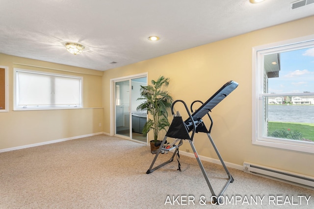 exercise room featuring carpet floors, a baseboard radiator, baseboards, and visible vents