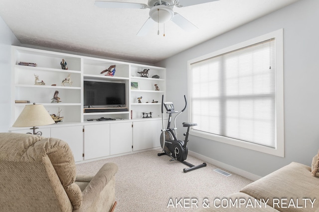 workout room with baseboards, light carpet, a ceiling fan, and visible vents