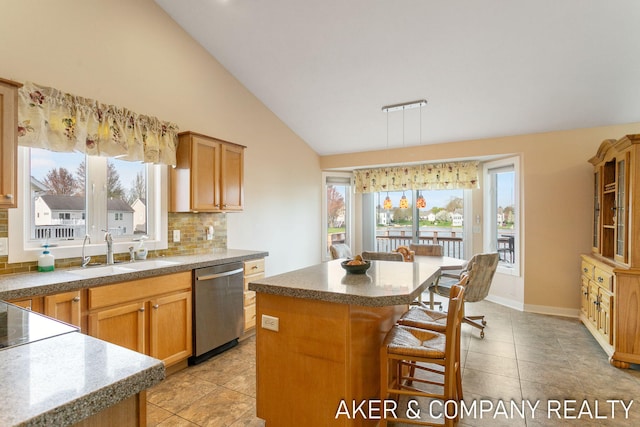kitchen featuring a breakfast bar area, tile countertops, stainless steel dishwasher, vaulted ceiling, and a sink