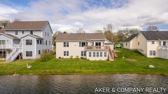 back of property with stairs, a lawn, and a deck with water view