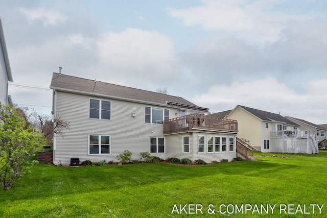 rear view of property featuring a lawn, a deck, and stairway
