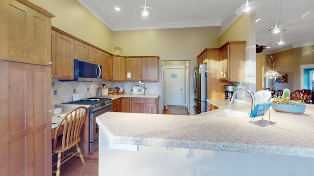 kitchen with a sink, appliances with stainless steel finishes, light countertops, a peninsula, and backsplash