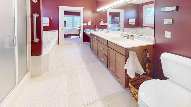 bathroom with a sink, tile patterned floors, ensuite bath, toilet, and double vanity