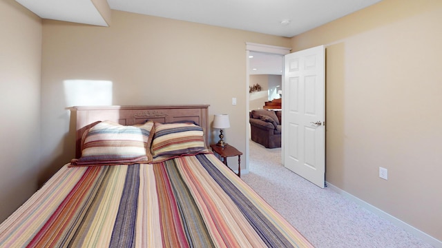 bedroom featuring light colored carpet and baseboards