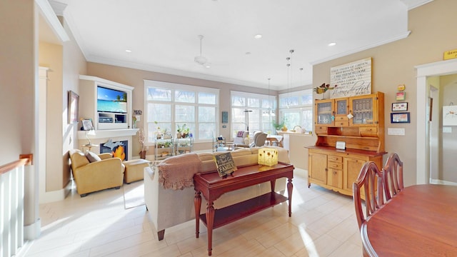 living area featuring recessed lighting, ornamental molding, and a warm lit fireplace