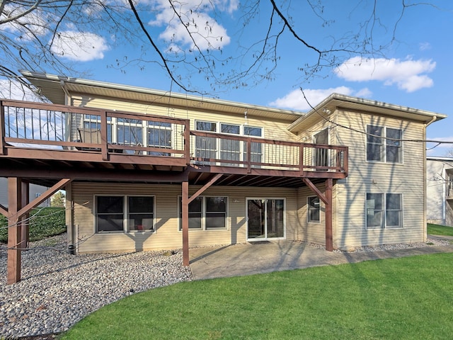 back of property with a lawn, a wooden deck, and a patio area