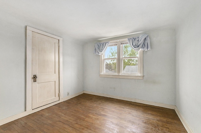 spare room with hardwood / wood-style flooring and baseboards