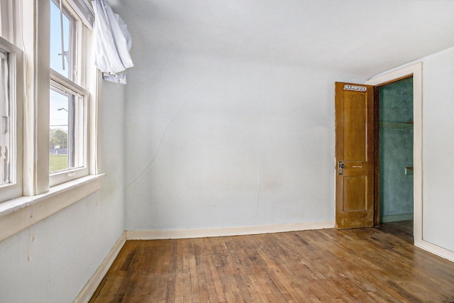empty room featuring hardwood / wood-style flooring and baseboards