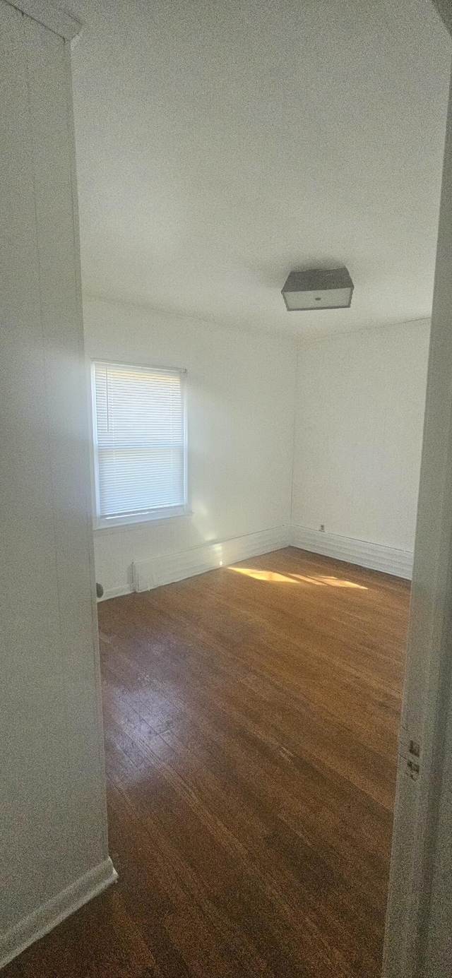 empty room with baseboards and wood finished floors