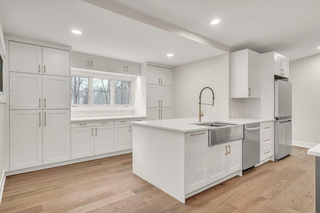 10985 E Cd Ave, Richland, MI 49083 - kitchen with light wood finished floors, a sink, stainless steel appliances, white cabinetry, and light countertops