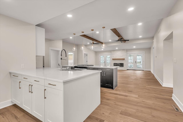 10985 E Cd Ave, Richland, MI 49083 - kitchen with beam ceiling, ceiling fan, a stone fireplace, a peninsula, and open floor plan