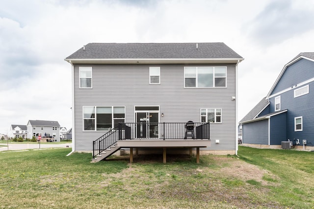 rear view of house featuring central AC unit, a yard, and a deck