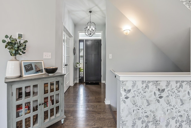 entryway featuring baseboards, dark wood finished floors, and a notable chandelier