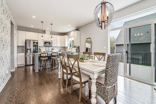 dining room featuring an inviting chandelier, recessed lighting, and dark wood-type flooring