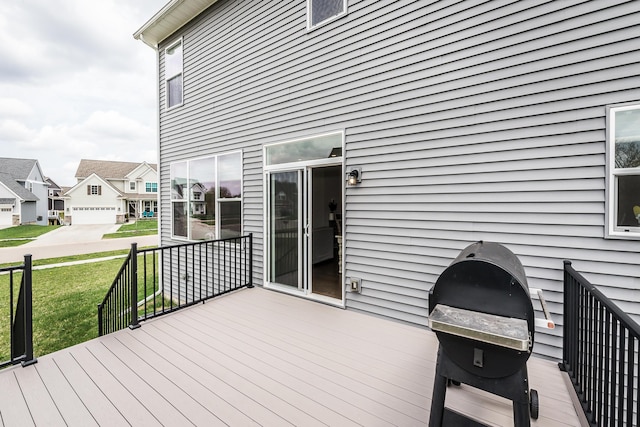wooden deck featuring a residential view, a yard, and area for grilling