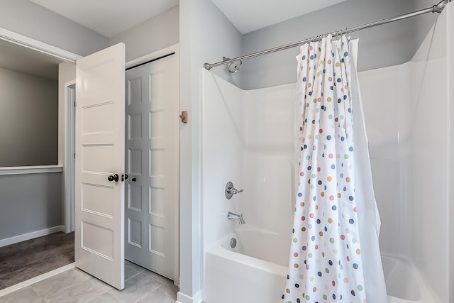 bathroom featuring baseboards, tile patterned flooring, and shower / tub combo with curtain