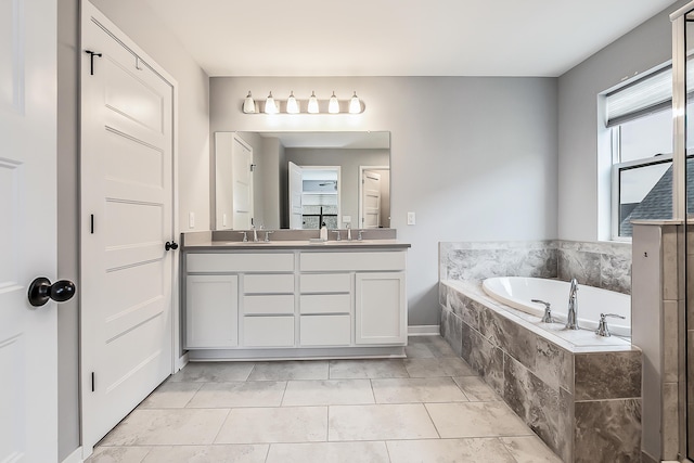 bathroom with double vanity, tile patterned floors, a sink, and a bath