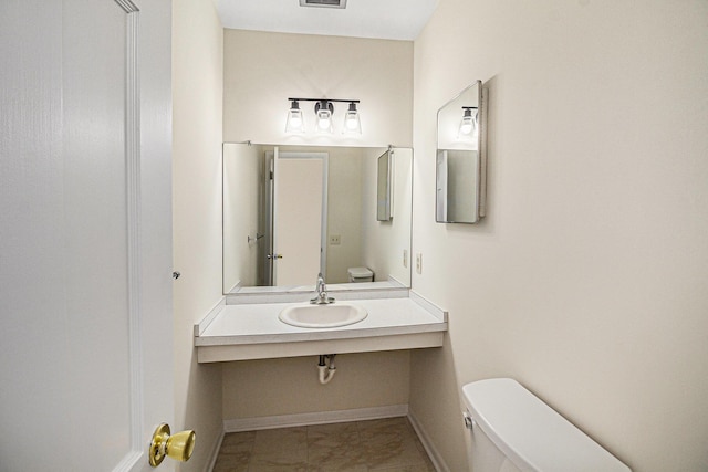2038 S 7th St, Ann Arbor, MI 48103 - half bathroom featuring a sink, toilet, marble finish floor, baseboards, and visible vents