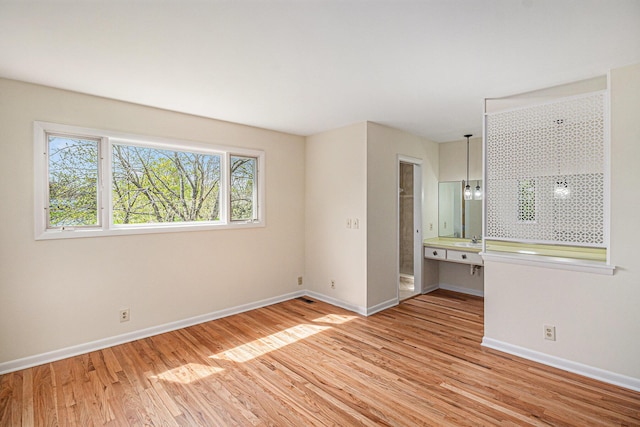 2038 S 7th St, Ann Arbor, MI 48103 - spare room featuring baseboards, a sink, and light wood-style flooring