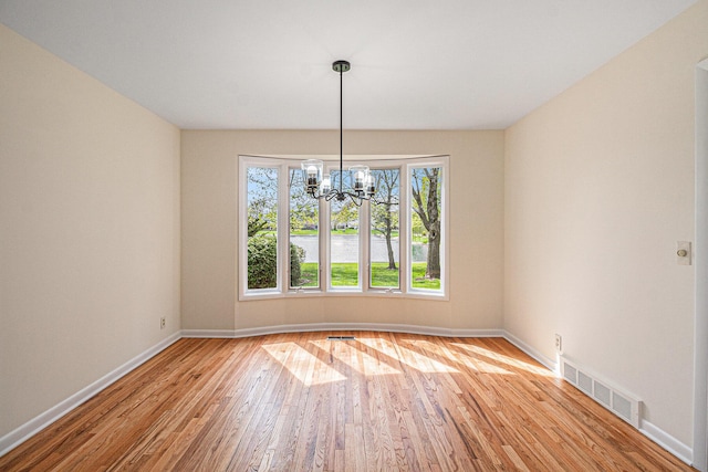 2038 S 7th St, Ann Arbor, MI 48103 - unfurnished dining area with visible vents, baseboards, wood finished floors, and a chandelier
