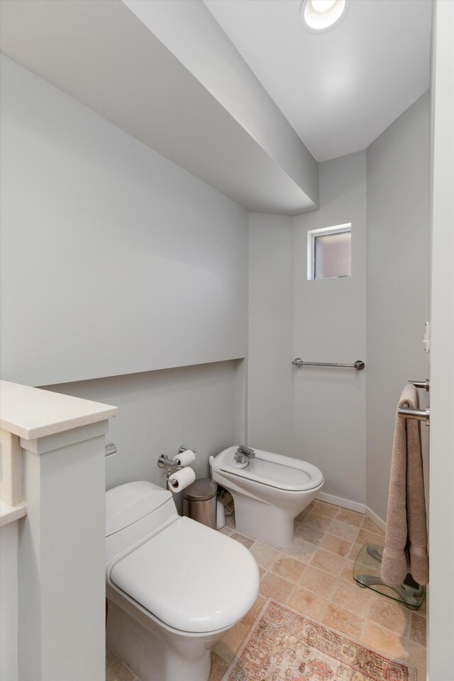 223 E Ann St Unit 1, Ann Arbor, MI 48104 - bathroom with stone finish floor, baseboards, and toilet