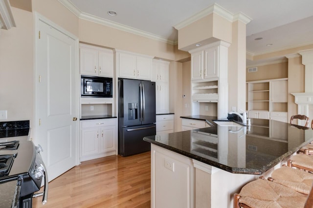 8660 Oakland Hills Cir, Portage, MI 49024 - kitchen featuring light wood-style floors, crown molding, a breakfast bar area, and black appliances