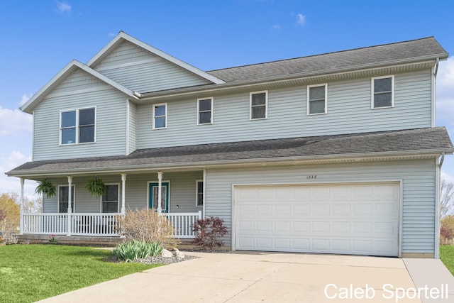 traditional-style home featuring a porch, an attached garage, driveway, and a front lawn