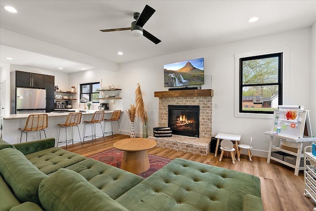 12950 Flynn Rd, Sawyer, MI 49125 - living room featuring light wood-style flooring, a ceiling fan, a fireplace, recessed lighting, and baseboards