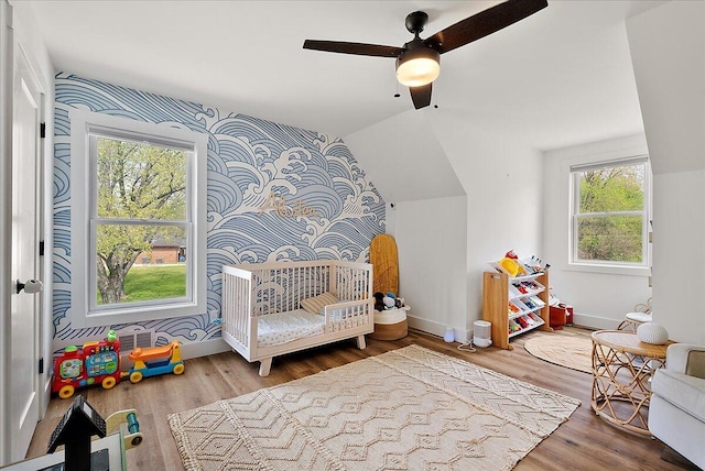 12950 Flynn Rd, Sawyer, MI 49125 - bedroom with wood finished floors, baseboards, vaulted ceiling, wallpapered walls, and a ceiling fan