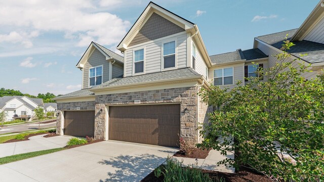 3100 Millbury Ln, Ann Arbor, MI 48105 - craftsman-style home with a garage, stone siding, and concrete driveway