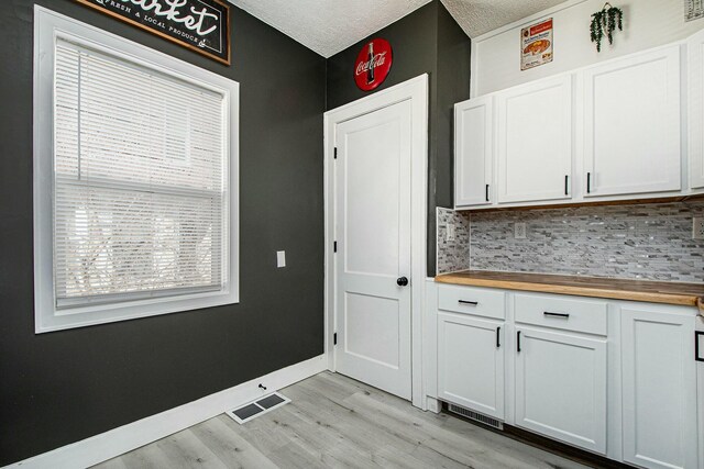 1146 Hall St SE, Grand Rapids, MI 49507 - kitchen with visible vents, decorative backsplash, butcher block counters, baseboards, and light wood-type flooring