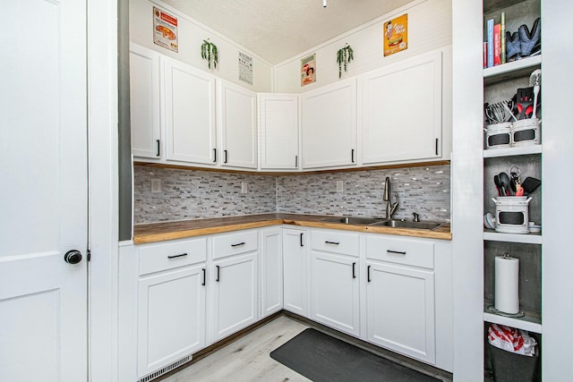 1146 Hall St SE, Grand Rapids, MI 49507 - kitchen with butcher block counters, a sink, light wood finished floors, and tasteful backsplash