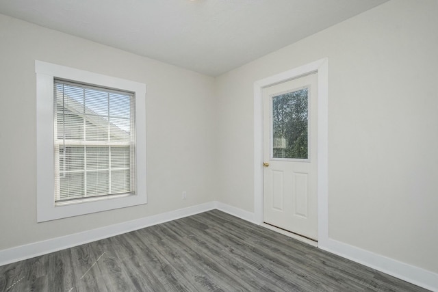 1146 Hall St SE, Grand Rapids, MI 49507 - spare room featuring baseboards and dark wood-style floors