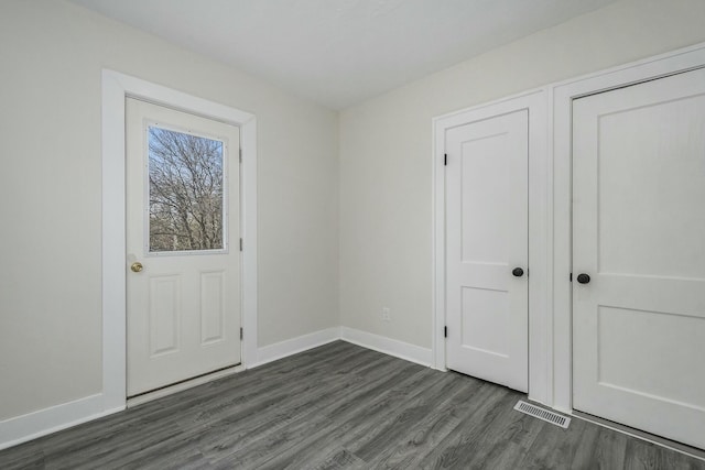 1146 Hall St SE, Grand Rapids, MI 49507 - doorway featuring baseboards, visible vents, and dark wood-type flooring