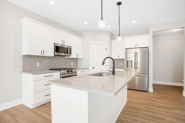 kitchen featuring light wood-style floors, a sink, recessed lighting, and stainless steel appliances