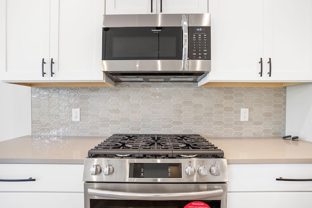 kitchen featuring light countertops, stainless steel appliances, white cabinets, and backsplash