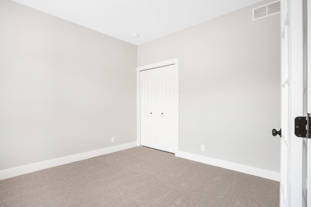 unfurnished bedroom with carpet floors, baseboards, a closet, and visible vents