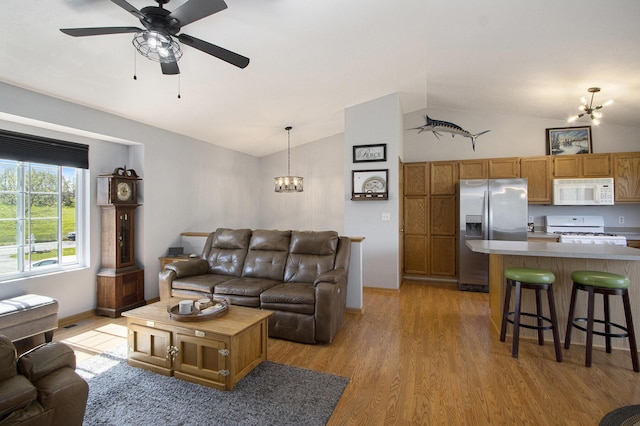1077 Sun Valley Ln, Allegan, MI 49010 - living area with baseboards, vaulted ceiling, light wood finished floors, and ceiling fan with notable chandelier