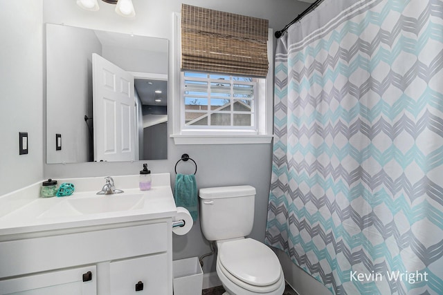 bathroom featuring toilet, a shower with shower curtain, and vanity
