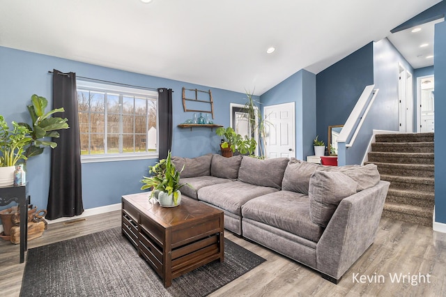 living room featuring stairway, baseboards, and wood finished floors