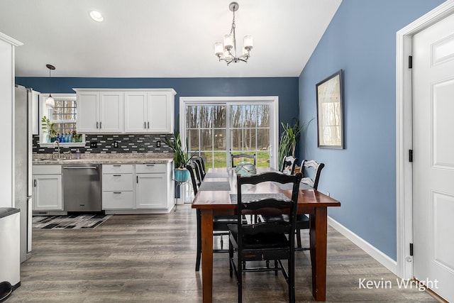 dining space featuring baseboards, recessed lighting, dark wood finished floors, a notable chandelier, and vaulted ceiling