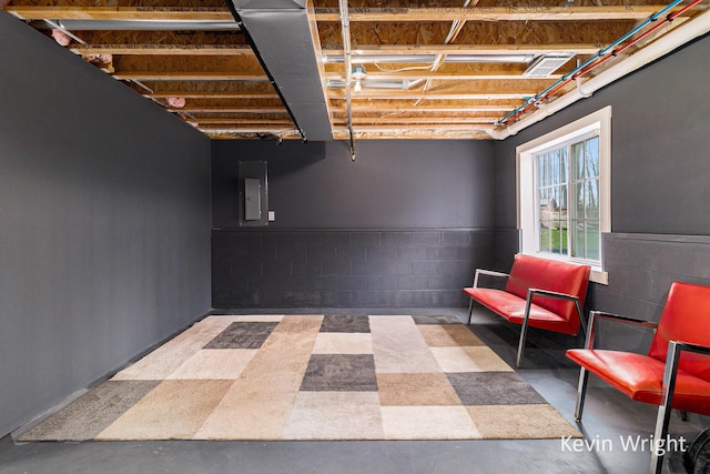 below grade area featuring electric panel and concrete block wall
